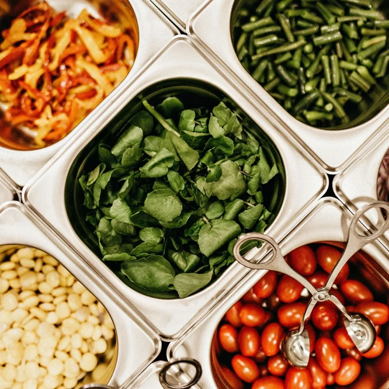 Fresh salad ingredients arranged in preparation trays